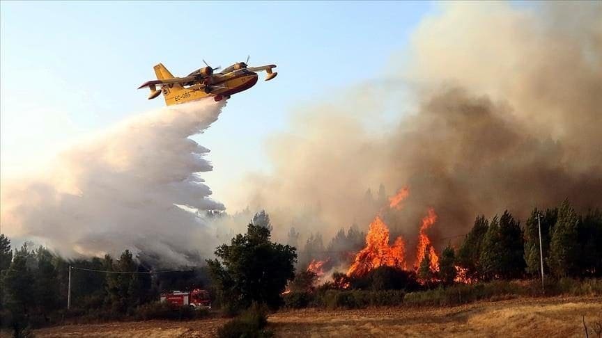 Wildfire in Spain with firefighting plane over dry countryside