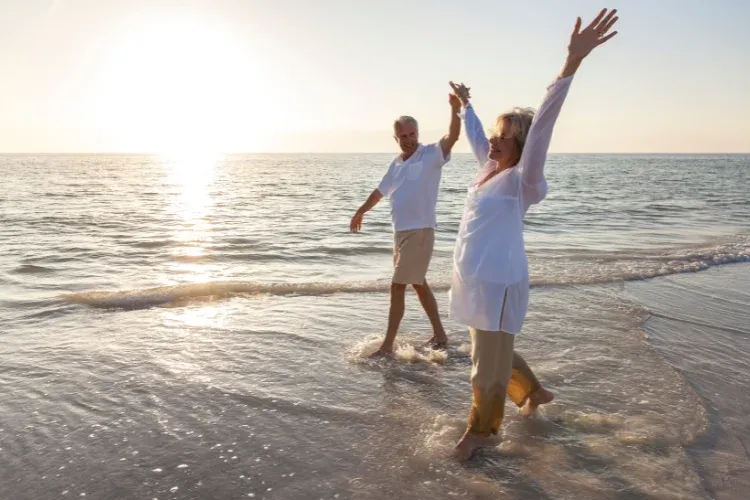 People walking along a Costa del Sol beach in winter sunshine. Non-Lucrative Visa 2026